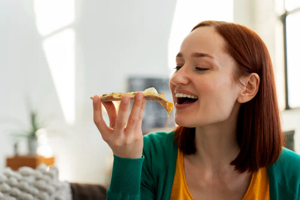 imagem de uma mulher jovem almoçando feliz com seus bons habitos alimentares